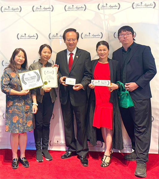 《弦系中西》制片人邓圩（左一）、导演张伟民（左二），主角薛苏里（左三）及主创人员手持奖状在电影节现场合影。黄甦摄