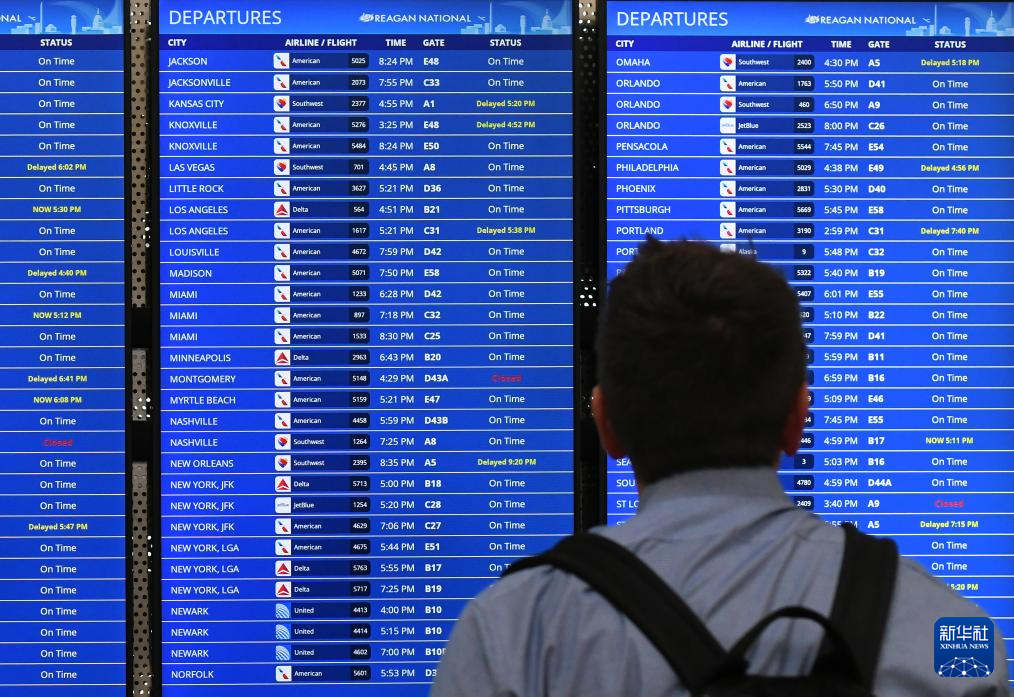 10月10日，在美国弗吉尼亚州阿灵顿的里根国家机场，一名男子查看航班信息。新华社记者 李睿 摄