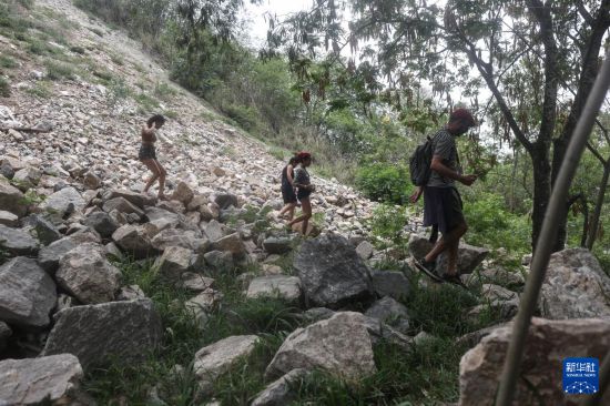 10月29日，在巴西里约热内卢的佩尼亚社区，人们在警方行动后的山坡地区搜索被击毙的犯罪嫌疑人遗体。新华社发（克劳迪娅·马尔提尼摄）