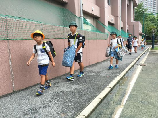 2016年8月30日，在日本东京，学生们背着书包携带各种学习用品走在校园里。新华社记者华义摄