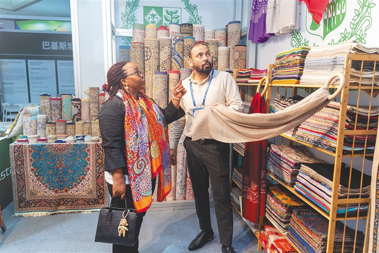 12月4日，在冬交会主宾国之一的巴基斯坦馆，来自乌干达的参展商在选购商品。海南日报全媒体记者 袁琛 摄