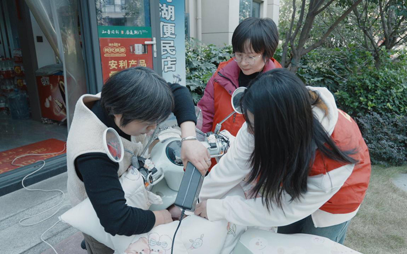 志愿者协助零售户整理电动车充电线路。