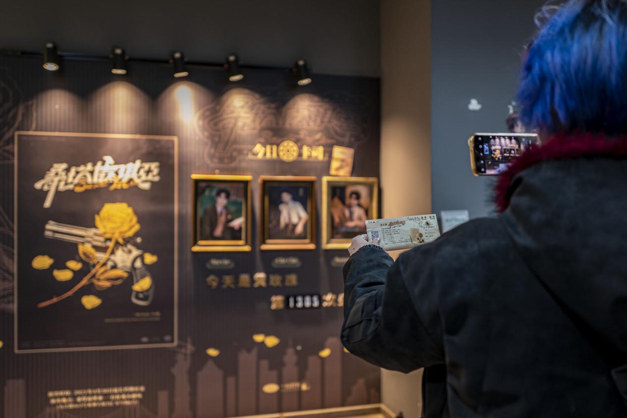 二楼音乐剧《桑塔露琪亚》剧场门口，观众正拿着票根打卡拍照。