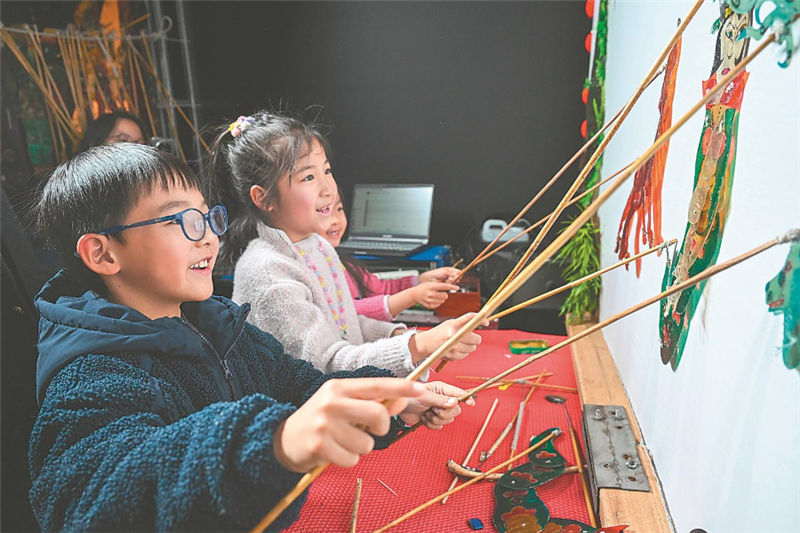 小观众体验皮影戏表演。