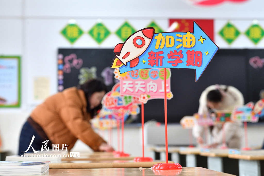 2026年3月2日，在湖北襄阳保康县实验小学，教师正在整理学生课桌上的新教材，认真做好开学前的各项准备工作。杨韬摄（人民图片网）