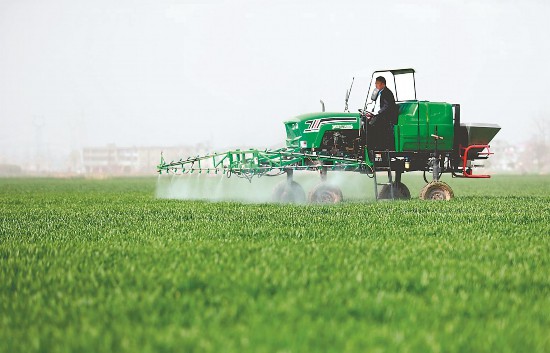 2月22日，在阜阳市颍东区新华街道浩丰种植专业合作社，农民驾驶自走式高杆喷雾机对小麦进行喷药作业。本报通讯员 宿飞 摄
