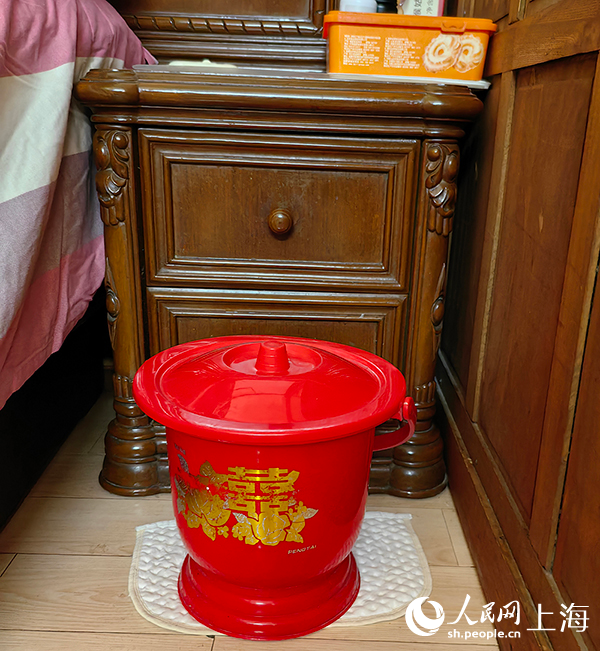 张自妹家的床脚保留着一只手拎马桶。人民网记者 唐小丽摄